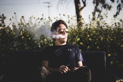 Man sitting on bench and vaping